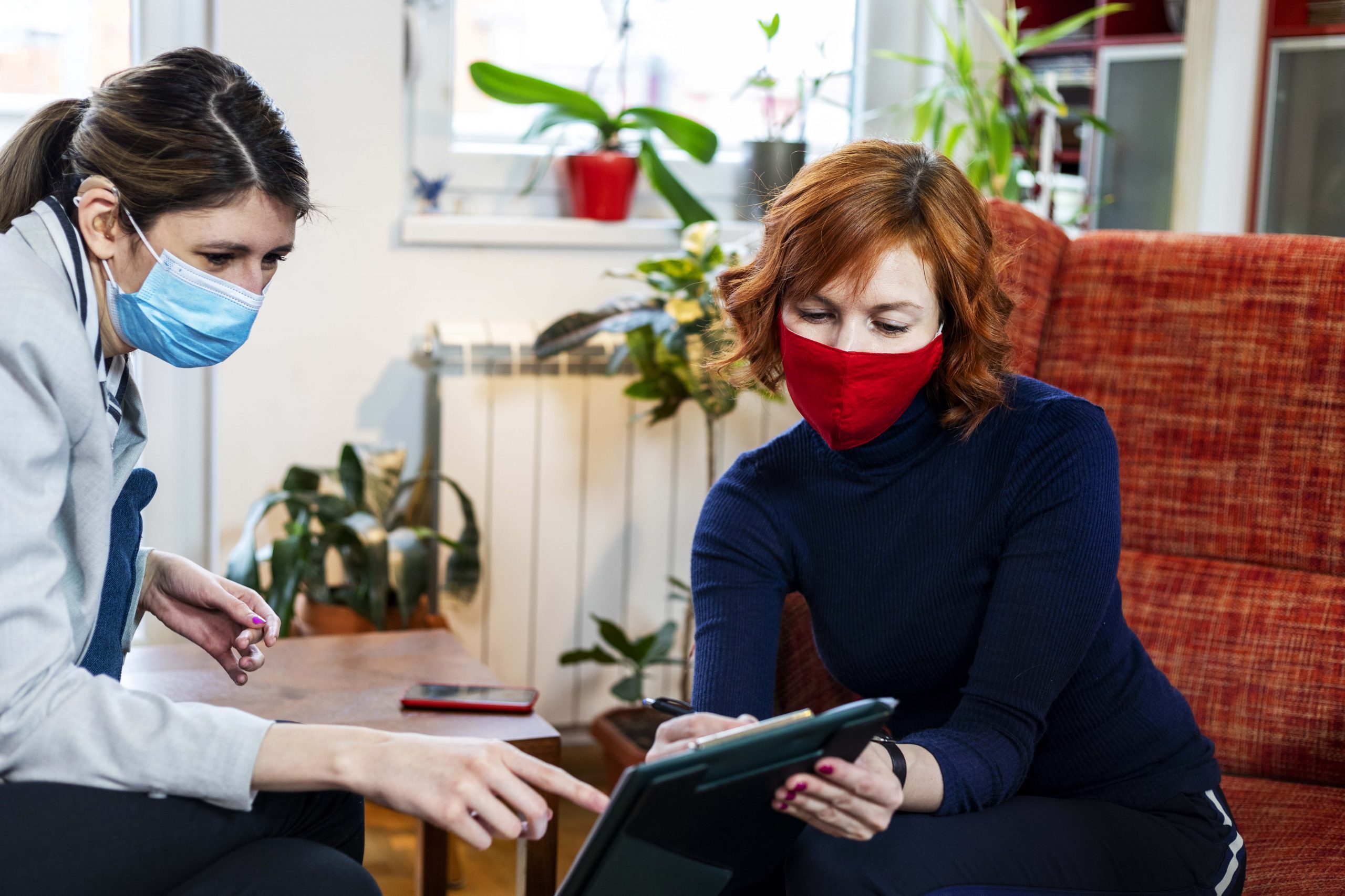 Woman social worker talking with a woman, client.