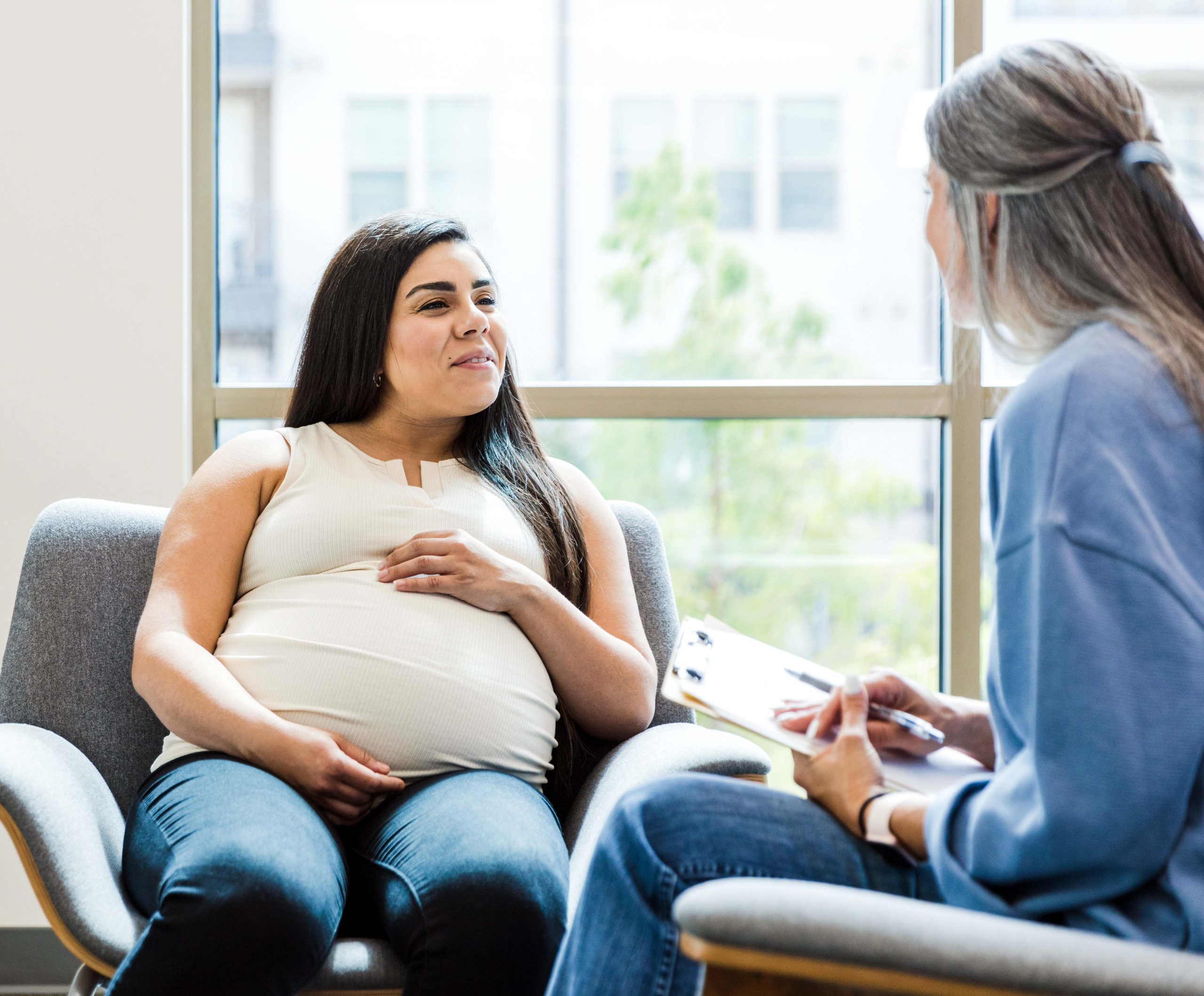 Pregnant woman talking with a social worker.