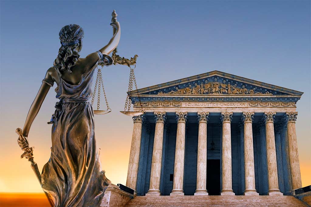 statue holds scales of justice next to United States Supreme Court