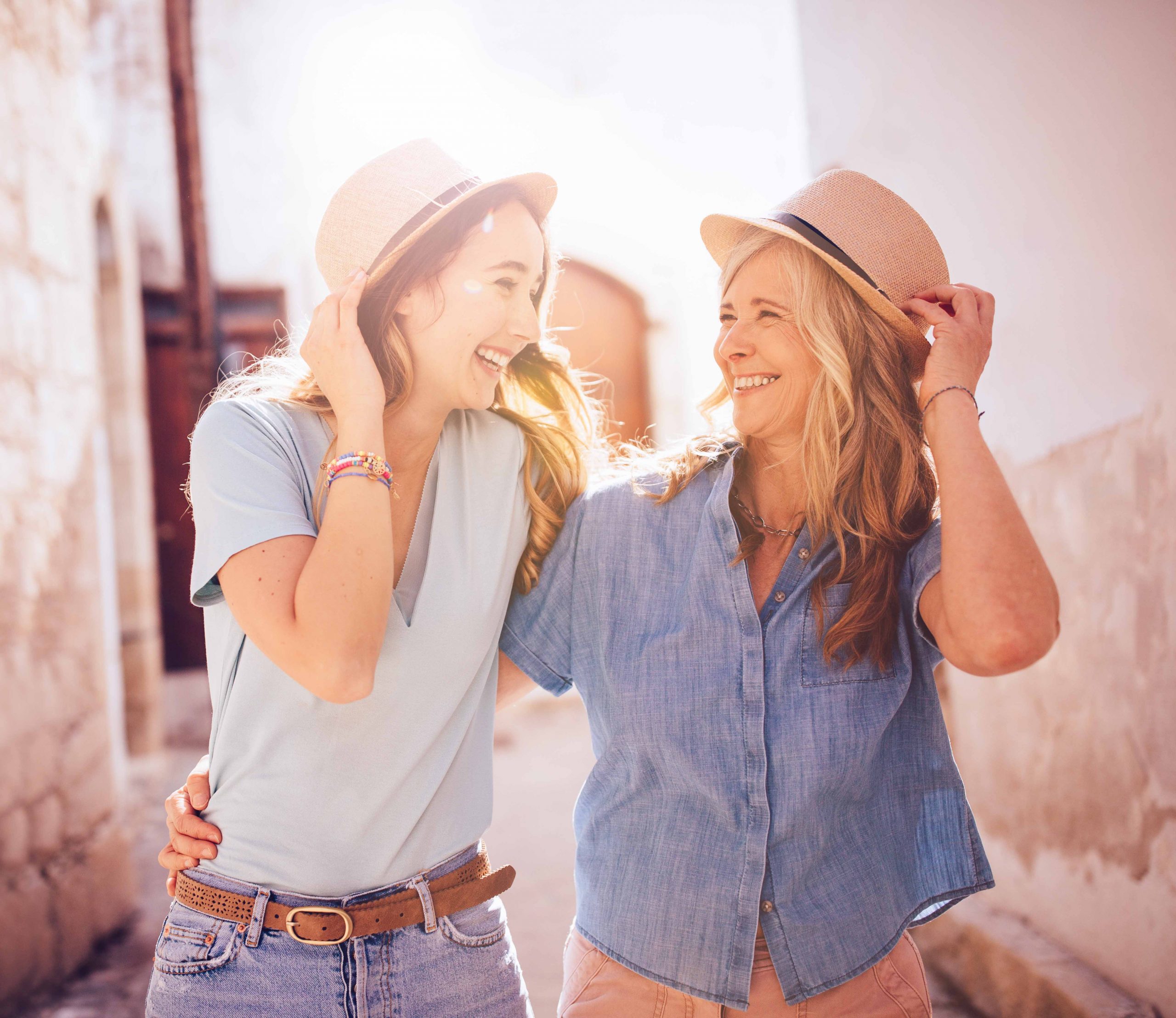 Mother and daughter on holiday walking in old village.